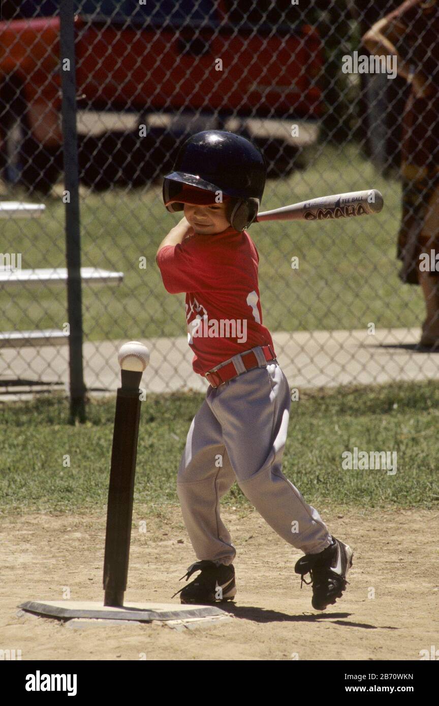 Austin, Texas USA: Giovane pastella prende un'oscillazione con la sua mazza alla sfera che si siede sul tee durante il gioco della lega di T-ball per i ragazzi e le ragazze di cinque e sei anni. SIGNOR ©Bob Daemmrich Foto Stock