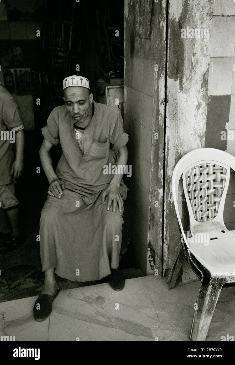 Fotografia di viaggio in bianco e nero - scena di strada di un uomo egiziano in Fatimid Islamico Vecchio Cairo in Egitto in Africa del Nord Medio Oriente Foto Stock