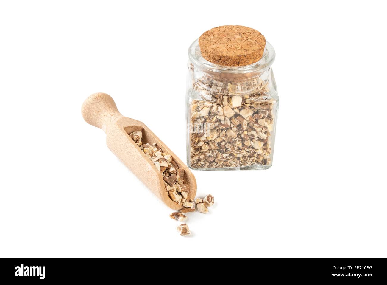 Radice di dente di leone o in latino Taraxaci radix in un vaso di vetro e scoop di legno isolato su sfondo bianco. Erbe medicinali curative Foto Stock
