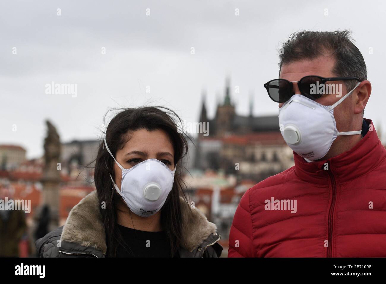 I turisti che indossano maschere facciali camminano vicino al centro di Praga, Repubblica Ceca, 12 marzo 2020. Il governo ceco ha dichiarato uno stato di emergenza di 30 giorni sul coronavirus in tutto il paese. Lo stato di emergenza può durare fino a 30 giorni e anche più a lungo con il consenso della Camera dei deputati. Sono vietati gli eventi con oltre 30 partecipanti, che si applicano a manifestazioni culturali, sportive, religiose, festival, pellegrinaggi, spettacoli, mercati e altri eventi. Lo Stato ha anche vietato l'ingresso nel paese agli stranieri dai paesi a rischio. (Foto Ctk/Michal Kamaryt) Foto Stock