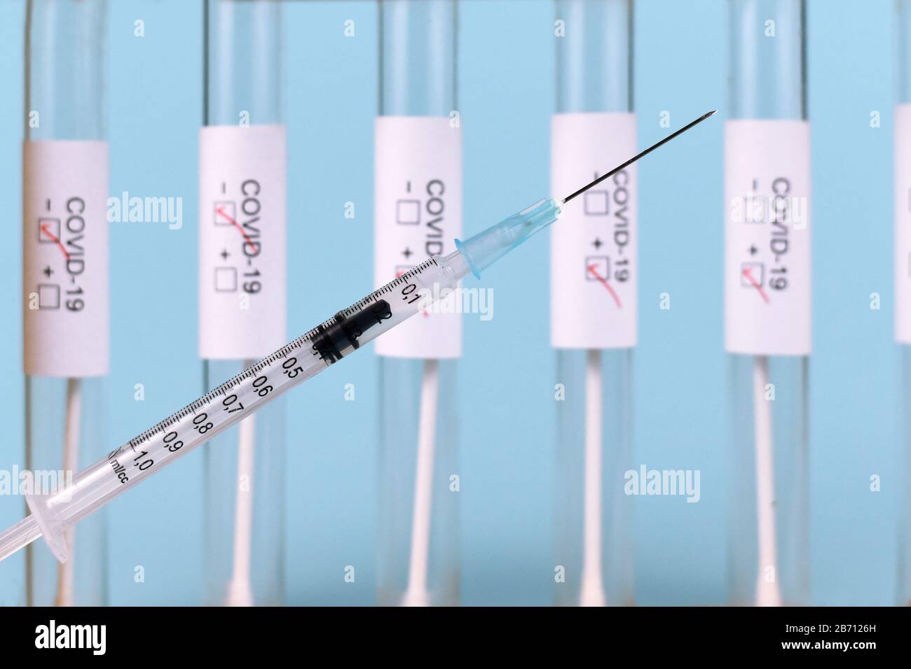 Siringa con campione di provetta per analisi medica per Coronavirus con etichetta Covid-19 su sfondo sfocato, concetto per lo sviluppo della vaccinazione Foto Stock