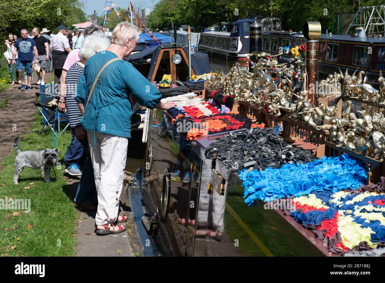 Persone che guardano vari beni in vendita da un narrowboat sui corsi d'acqua del Regno Unito durante un festival sui canali. Foto Stock