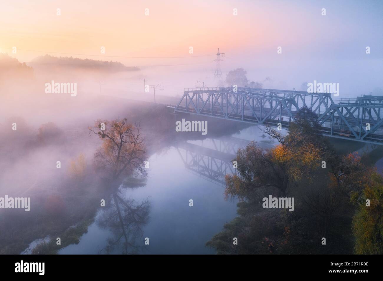 Vista aerea del bellissimo ponte ferroviario e del fiume in nebbia in autunno Foto Stock