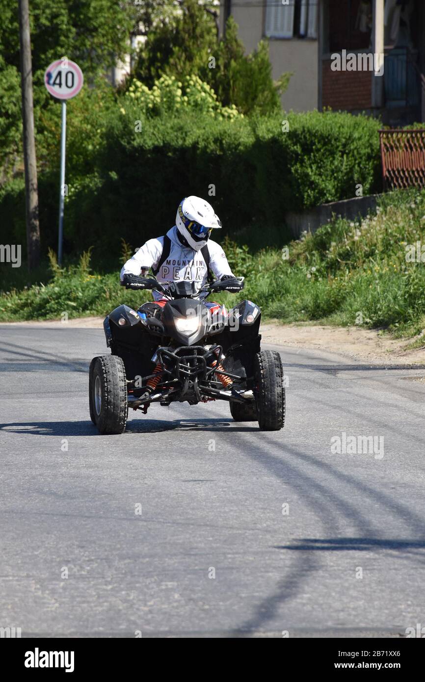 Un quad in bianco guida lungo la strada Foto Stock