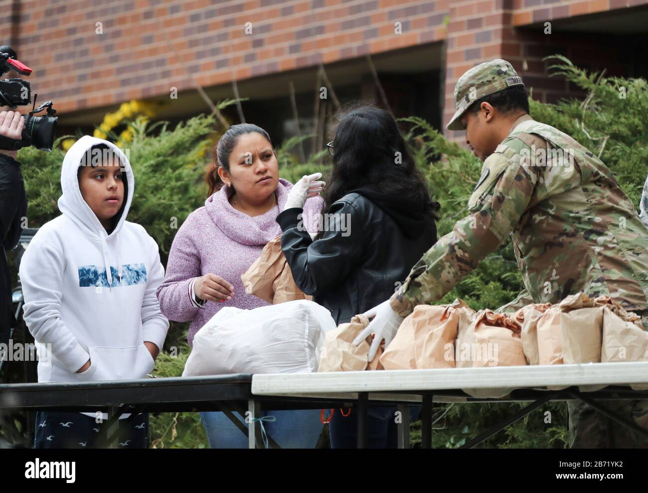 New York, Stati Uniti. 12th Mar, 2020. Un membro dello staff e un membro della Guardia Nazionale distribuiscono cibo a residenti qualificati vicino all'area di contenimento nel raggio di un miglio a New Rochelle, nello Stato di New York, negli Stati Uniti, il 12 marzo 2020. Lo stato statunitense di New York ha istituito una cosiddetta "area di contenimento" in un hotspot COVID-19 giovedì, con truppe della Guardia Nazionale spedite in loco per pulire le superfici e consegnare il cibo a persone in quarantena. Credito: Wang Ying/Xinhua/Alamy Live News Foto Stock