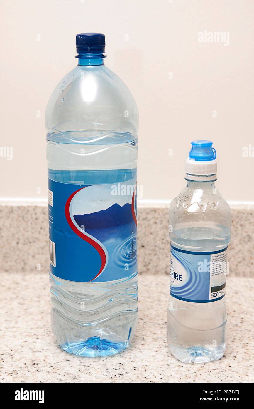 grandi e piccole bottiglie di plastica di acqua di sorgente Foto Stock