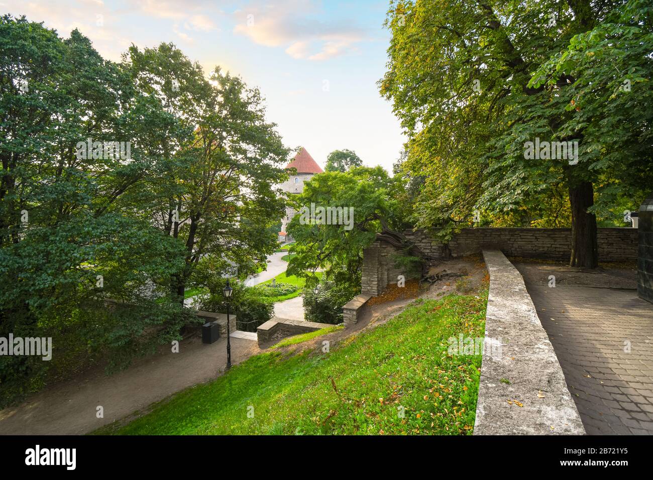 Un piccolo parco sulla collina di Toompea offre uno scorcio delle mura di pietra medievali e delle torrette della città murata di Tallinn, Estonia. Foto Stock