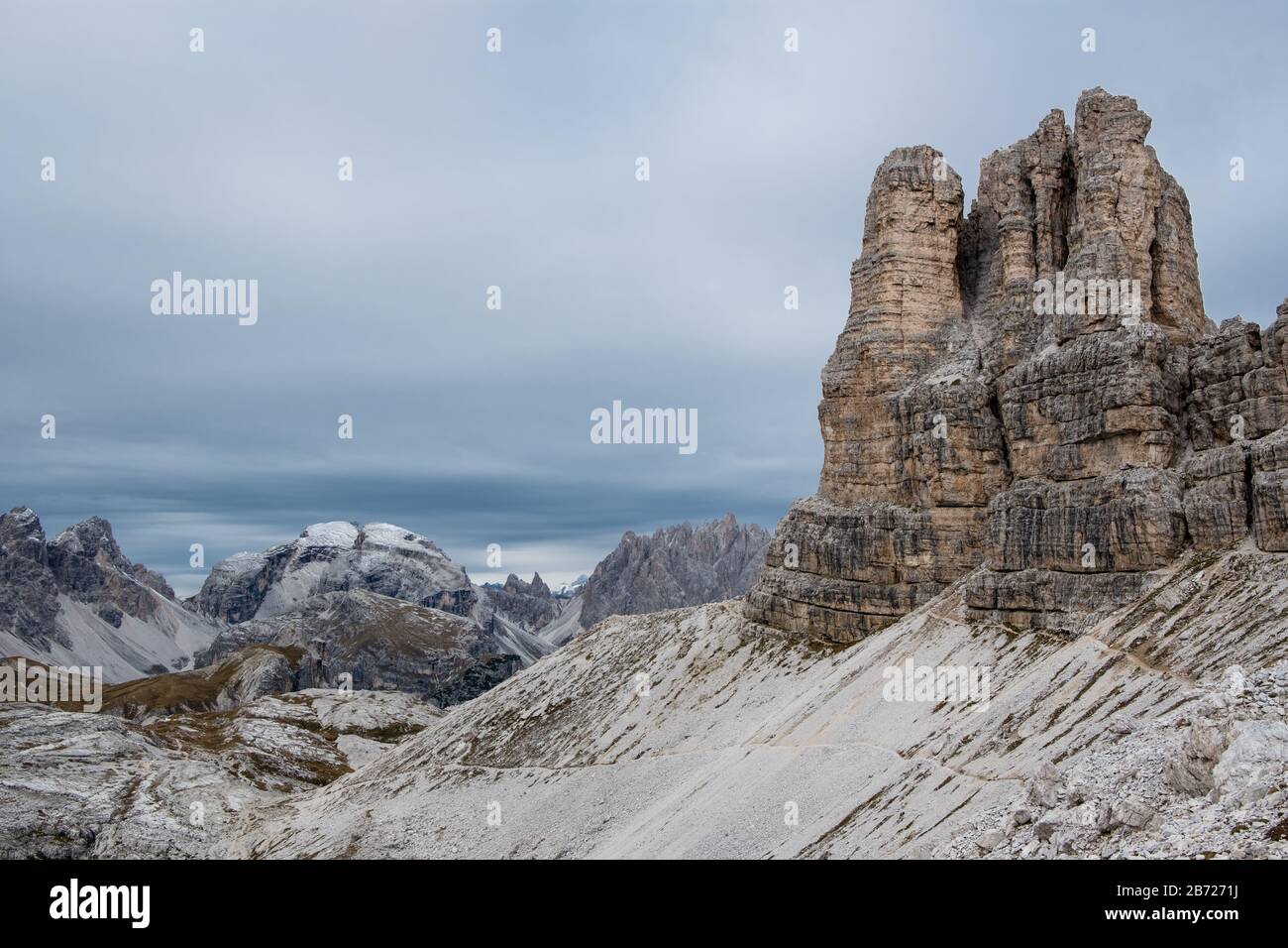 Le ripide cime e le cime frastagliate delle Dolomiti italiane nei pressi Dei Chimneys presentano una tavolozza muta sotto un cielo grigio uniforme che porta la neve nella zona Foto Stock