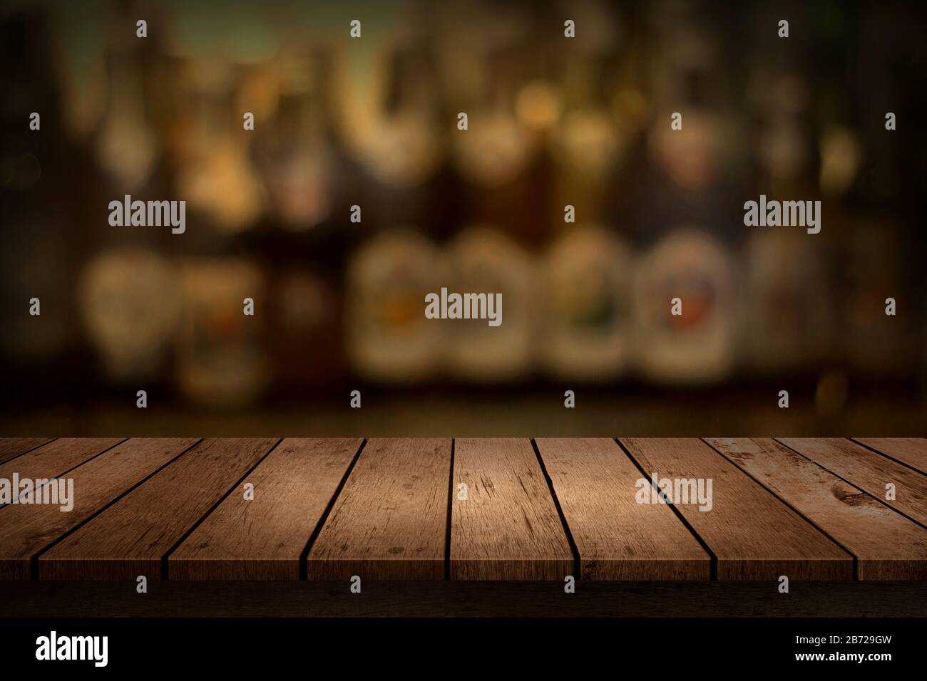 Tavolo in legno con vista di bevande sfocate bar bottiglia sfondo. Per la visualizzazione del prodotto di montaggio. Foto Stock