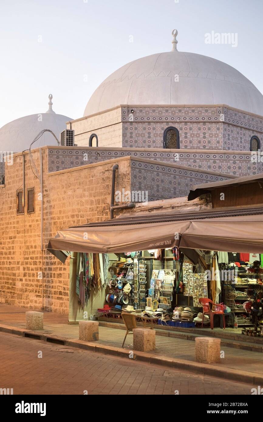Piccolo negozio nella città vecchia di Jaffa, sulle pareti esterne della Moschea Mahmoudiya costruita in epoca ottomana Foto Stock