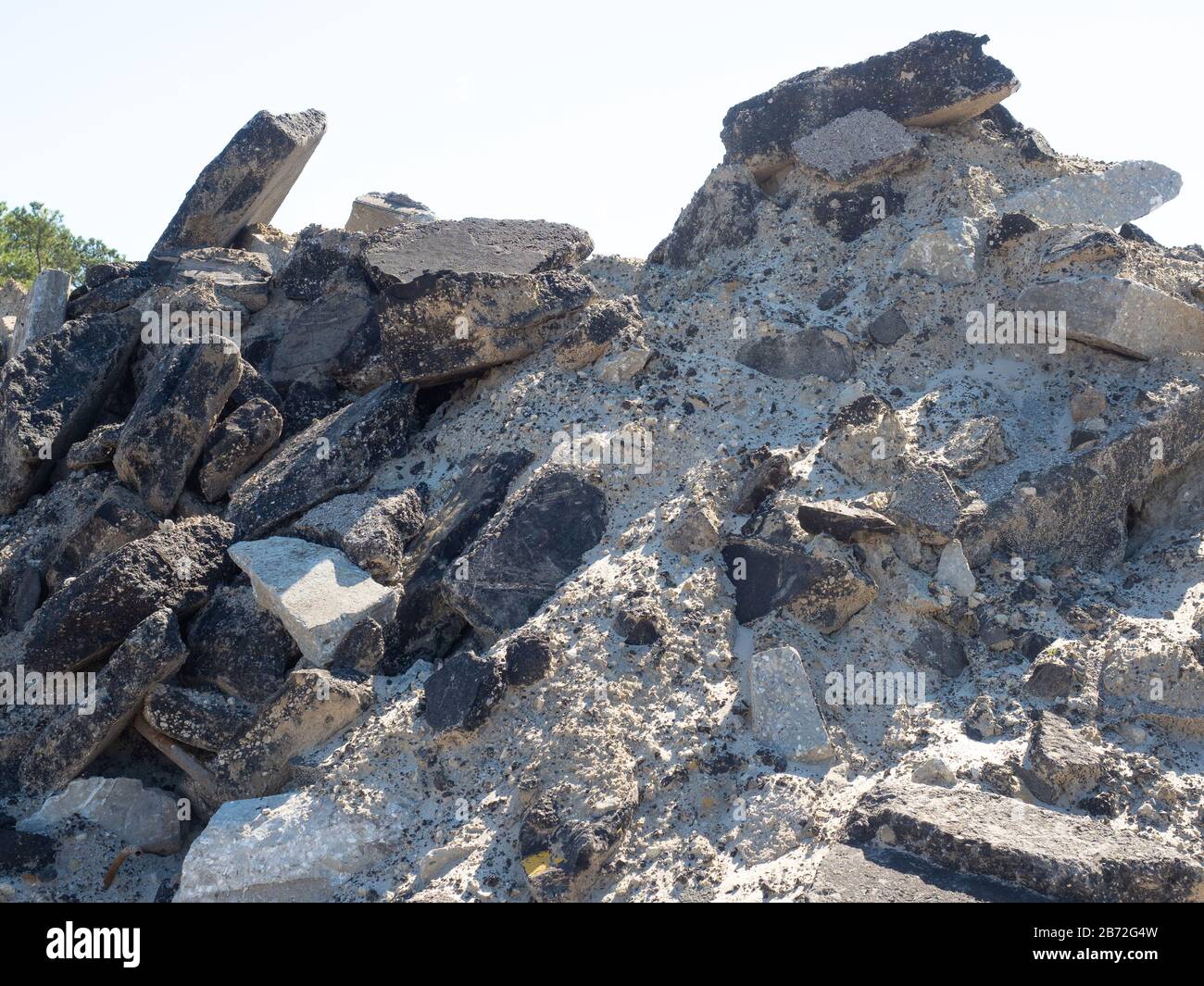 Montagna di macerie stradali, detriti di demolizione, enormi blocchi di pavimentazione stradale in cemento e asfalto asfaltato pavimentazione, cima di enorme mucchio Foto Stock