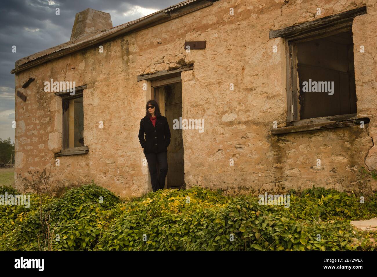 Travelerstands femminile in aperta porta di un vecchio storico colosso nel sud Flinders Ranges vicino Melrose in Australia Meridionale. Foto Stock