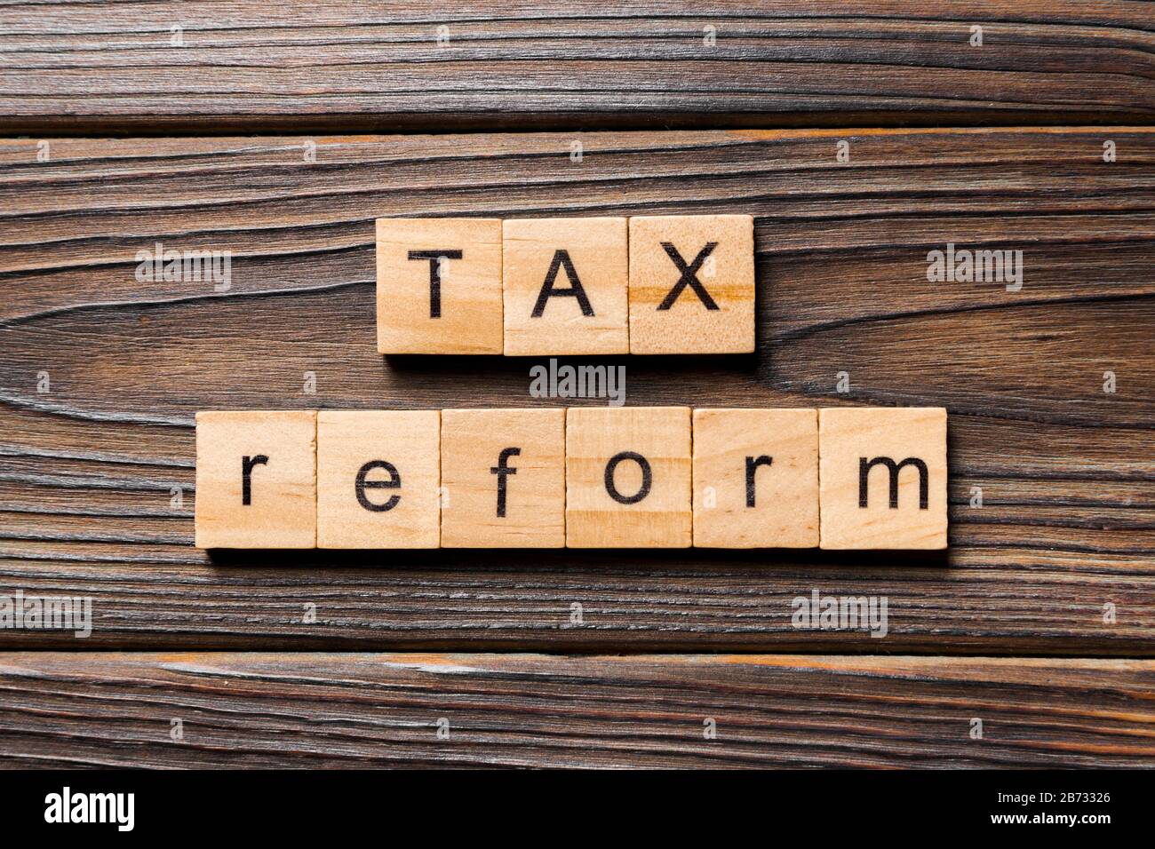 La riforma fiscale parola scritta sul blocco di legno. imposta il testo di riforma sul tavolo in legno per il desing, concetto. Foto Stock
