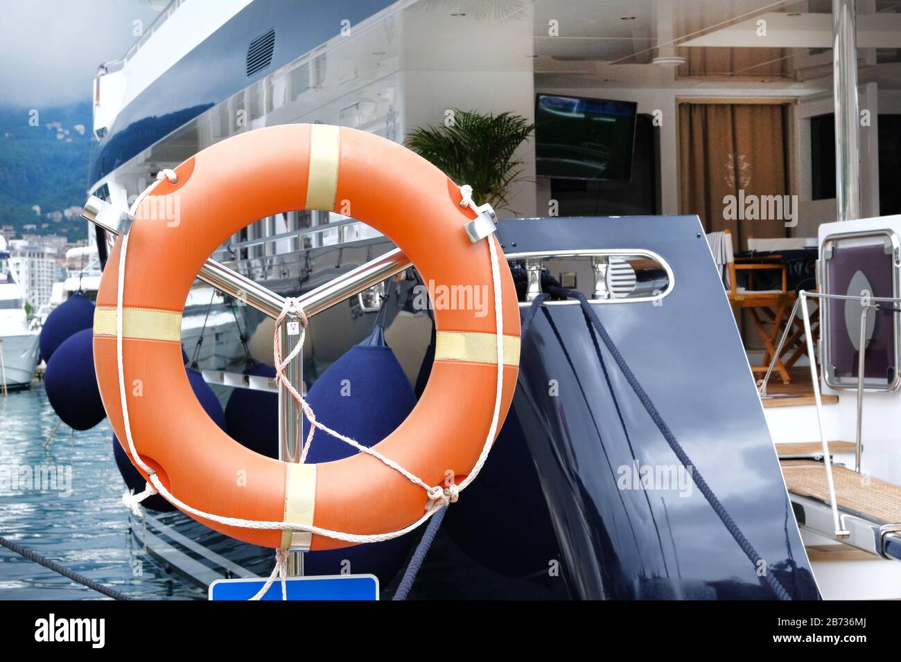 Lifebuoy arancione su yacht moderno. Concetto di salvataggio su acqua in estate. Foto Stock