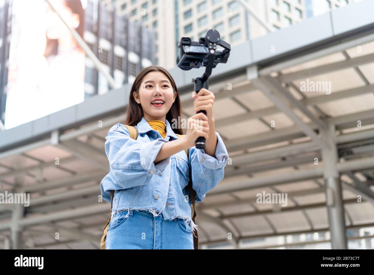 Sorridente bella donna asiatica viaggio vlogger turistico prendendo selfie video in città Foto Stock