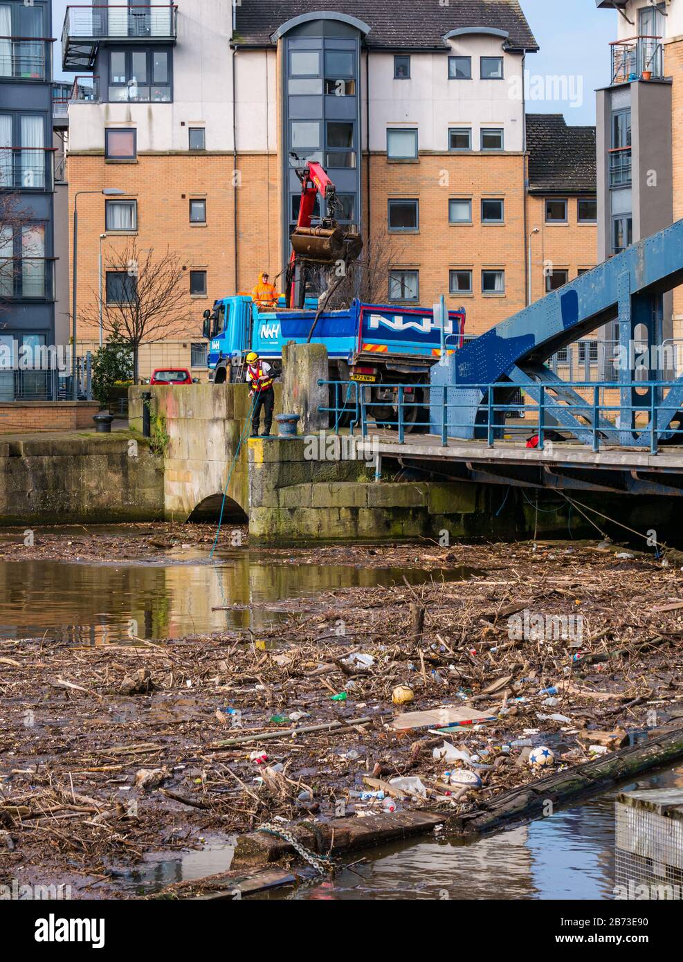 The Shore, Leith, Edimburgo, Scozia, Regno Unito. 13 Marzo 2020. Acqua di Leith pulizia: Frequenti piogge pesanti negli ultimi mesi causa un costante accumulo di rifiuti e detriti al vecchio ponte Victoria swing alla foce del fiume all'uscita di Leith Docks. E' un pericolo per gli animali fino a quando non è stato raggiunto un accordo tra il comune di Edimburgo, Water of Leith Conservation Trust & Forth Ports per un programma di manutenzione, ma il lavoro deve essere fatto a intervalli regolari, essendo stato fatto l'ultima volta in dicembre Foto Stock