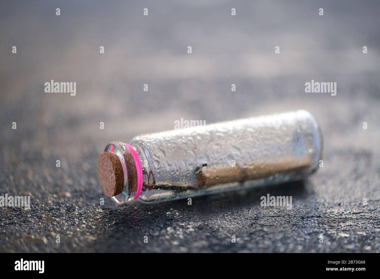 Primo piano di una bottiglia di vetro con un messaggio arrotolato all'interno intrecciati con un po' di spazio vuoto sulla parte superiore Foto Stock