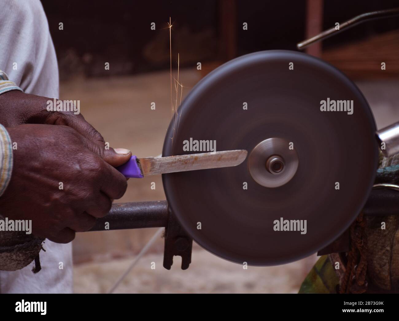 Affilare un coltello nella ruota di pietra alimentata dalla bicicletta Foto Stock