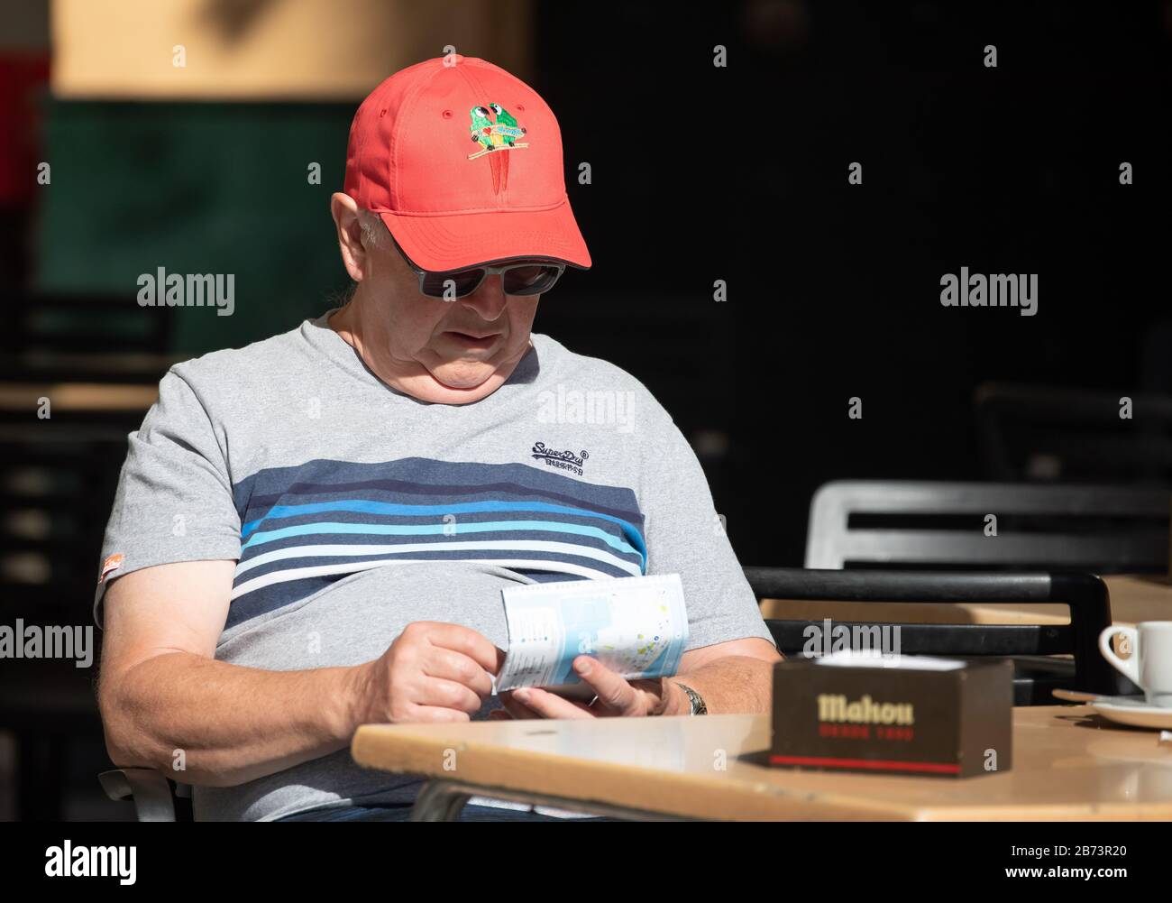 Un uomo studia una mappa mentre cena al fresco a Cadice, Spagna Foto Stock