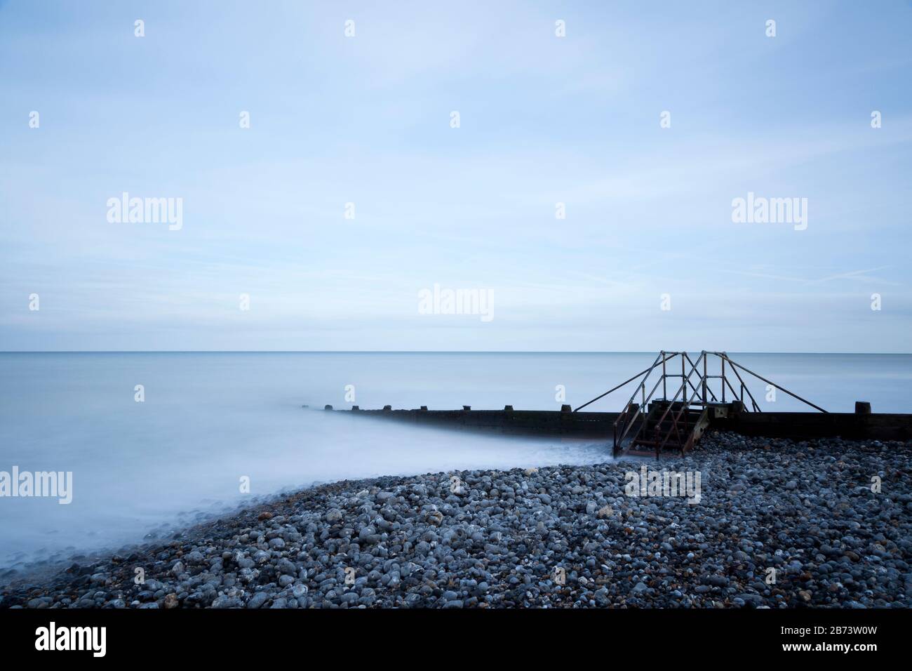 Scalini di metallo costruiti su una groyne su una spiaggia Foto Stock