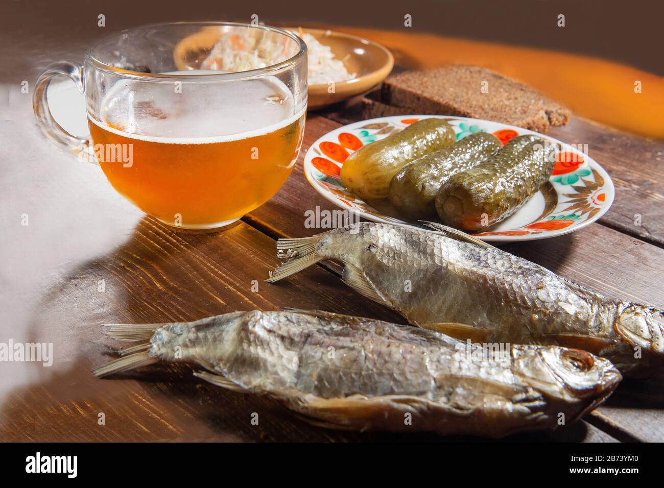 Birra e pesce secco TIPO VOBLA E cetrioli salati e pane nero a pezzetti Foto Stock