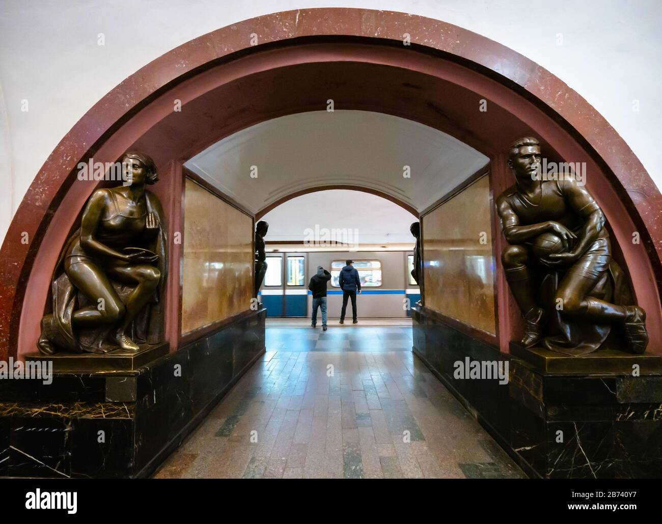 Sculture sull'arco a Piazza della Rivoluzione o alla stazione della metropolitana Ploshchad con treno sotterraneo alla piattaforma, metropolitana di Mosca, Federazione Russa Foto Stock