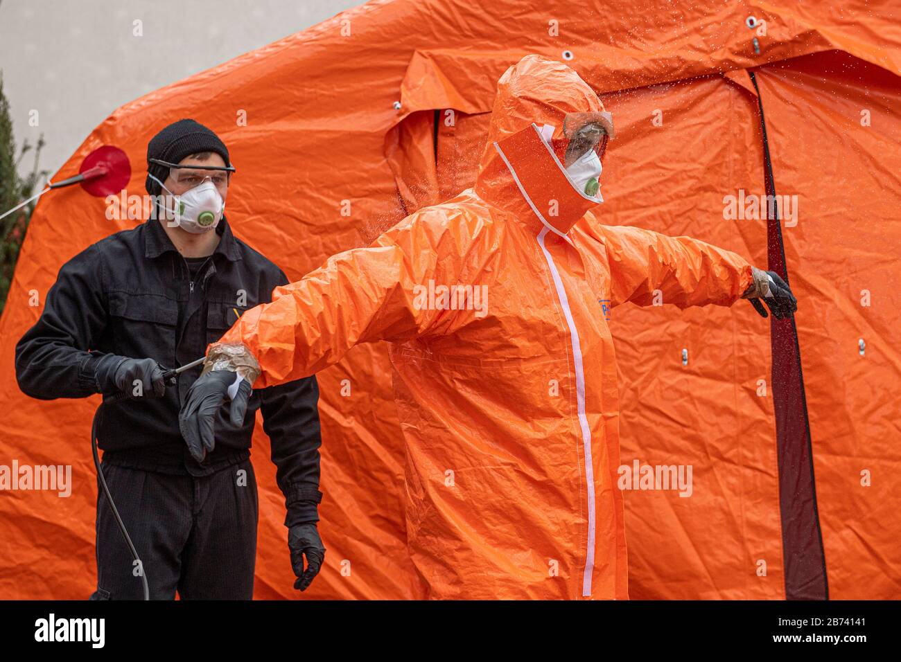 Kudowa Zdroj, Polonia. 13 Marzo 2020. Gli agenti di polizia di frontiera polacchi in tute protettive effettuano controlli medici e misurazioni della temperatura di conducenti e passeggeri provenienti dall'estero al valico di frontiera tra Polonia e Repubblica Ceca, il 13 marzo 2020, Nachod-Kudowa Zdroj, a causa delle preoccupazioni circa la diffusione del nuovo coronavirus. Sul poliziotto foto disinfetta il collega in tuta protettiva dopo uno dei controlli medici. Credit: David Tanecek/Ctk Photo/Alamy Live News Foto Stock