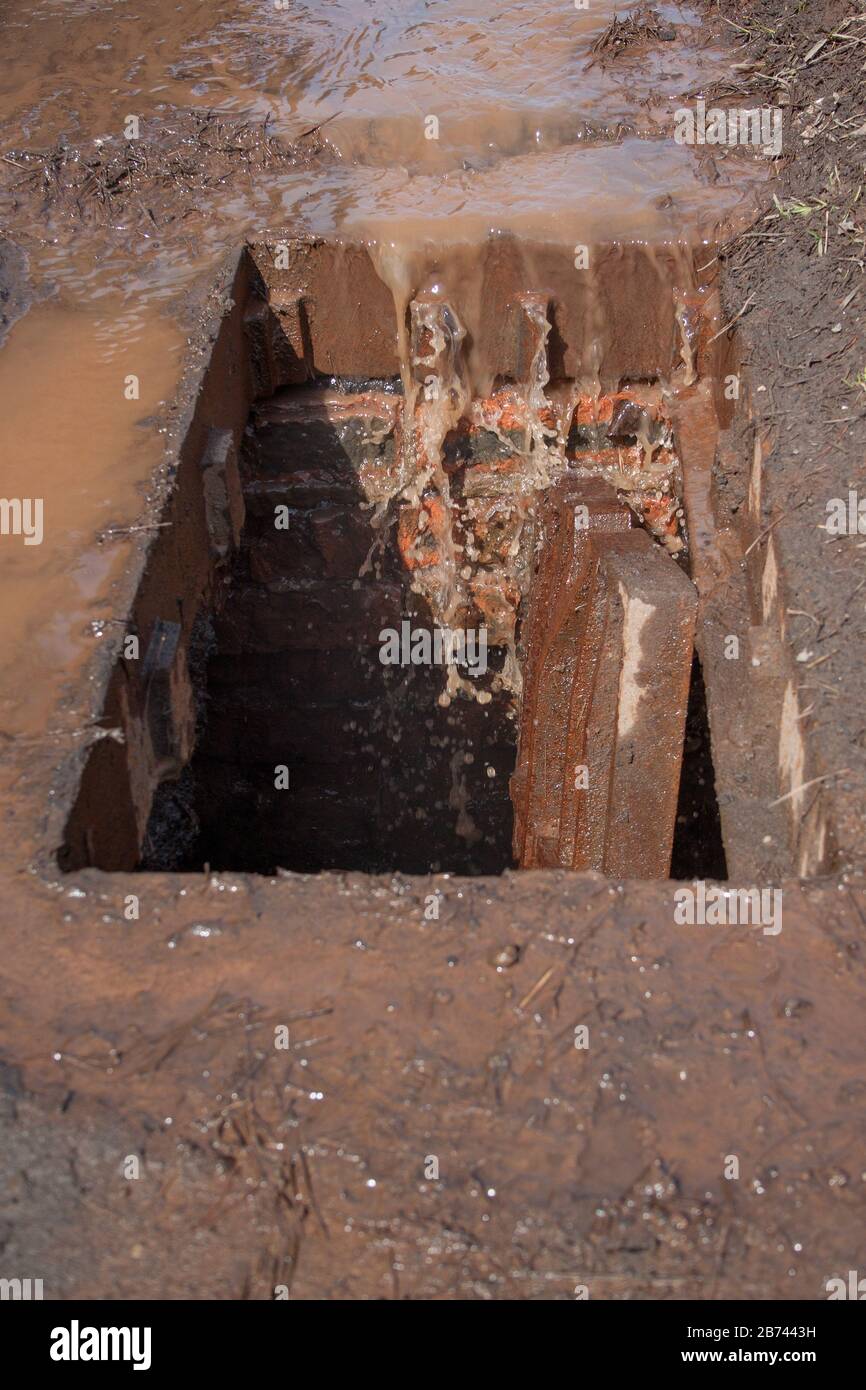 Griglia di drenaggio tempesta rotta. L'acqua sporca e la spazzatura entrano nella grondaia. Foto Stock