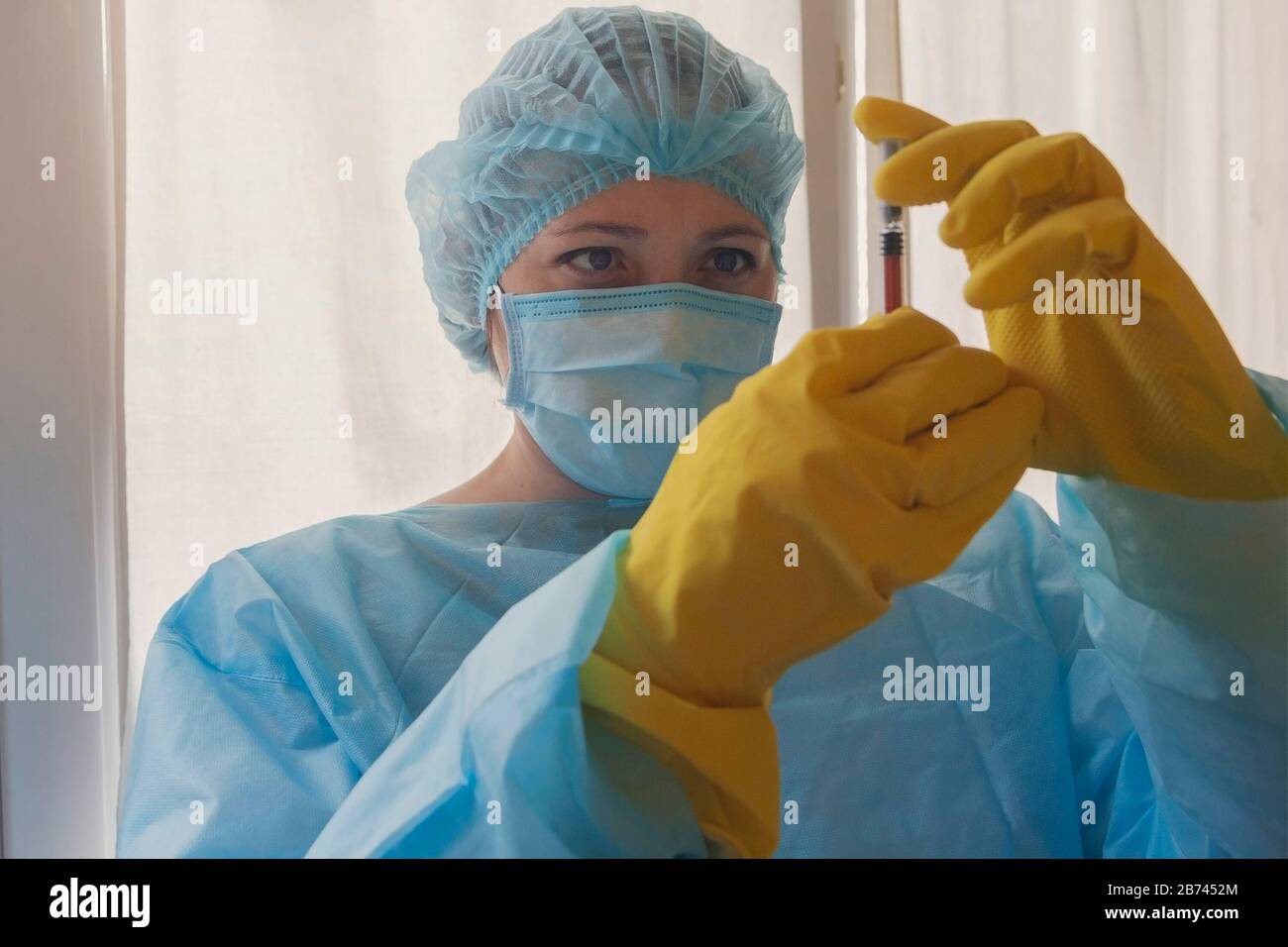 Donna dottore in abbigliamento protettivo e maschera in laboratorio. Medicina Foto Stock