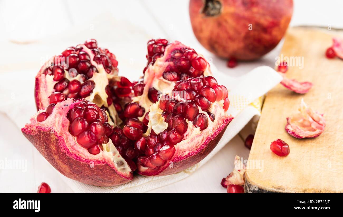 melograno rosso maturo su un tavolo di legno bianco Foto Stock