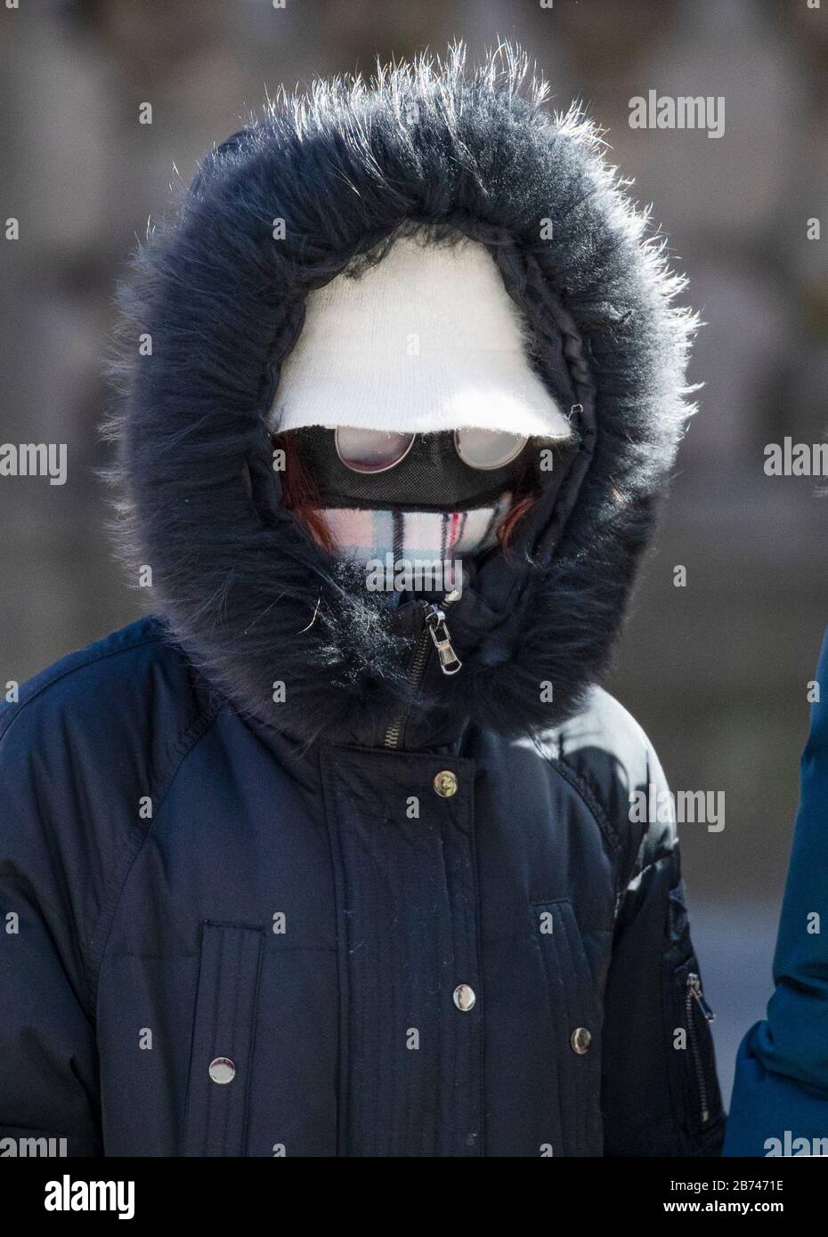 Una donna che indossa una maschera facciale protettiva cammina lungo il Royal Mile, Edimburgo, mentre il più alto scienziato del governo ha riscaldato che fino a 10,000 persone nel Regno Unito sono già infettati. Foto Stock