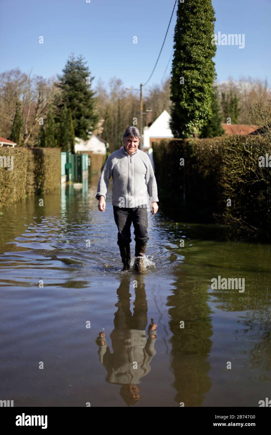 12 Marzo 2020. Beaumerie St Martin, Pas De Calais, Francia. Monsieur Patrice Sibilli percorre le inondazioni per aiutare suo fratello in un'alluvione vicina Foto Stock