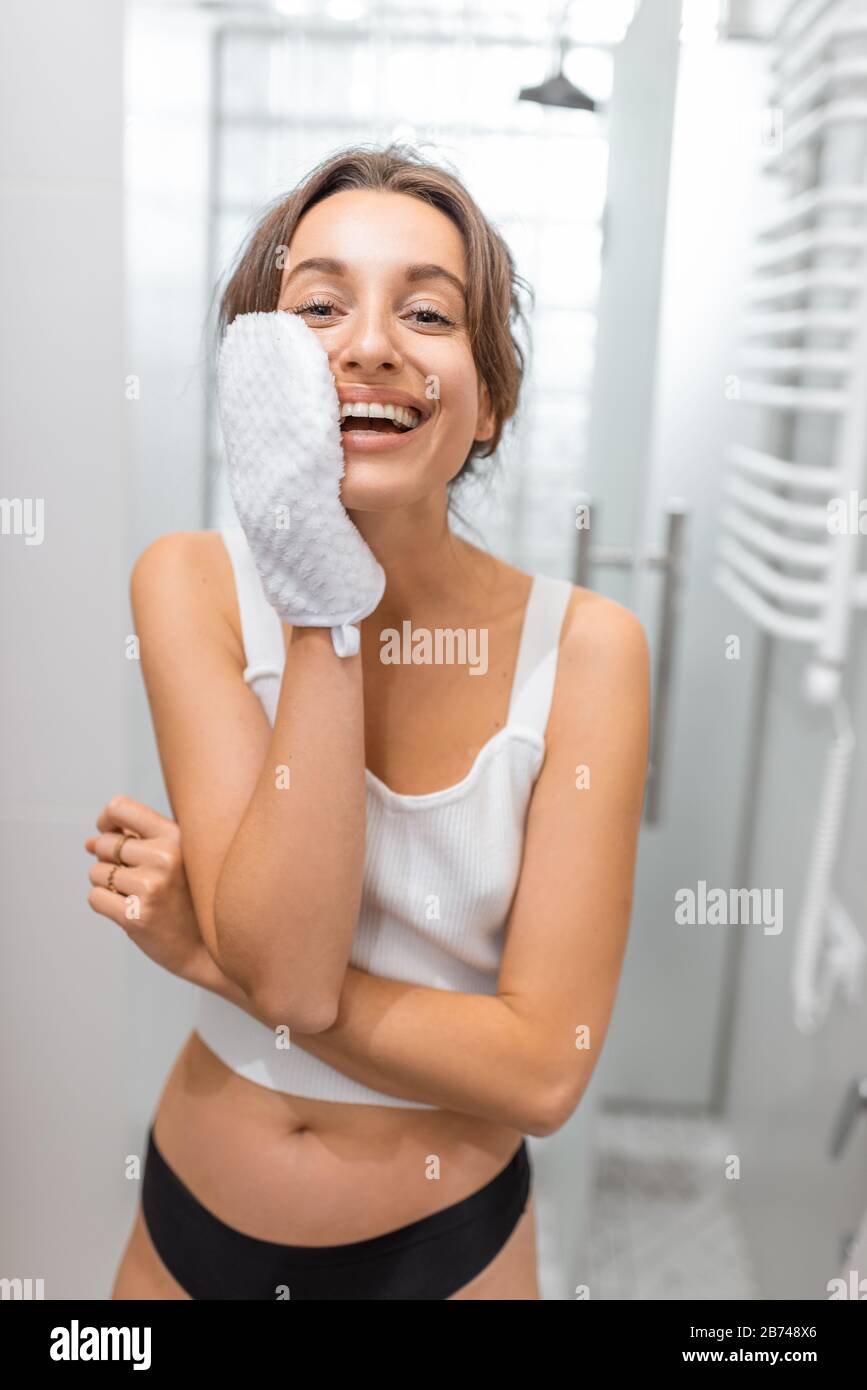 Ritratto di una giovane e allegra donna con un guanto doccia in bagno.  Concetto di self care e wellness Foto stock - Alamy