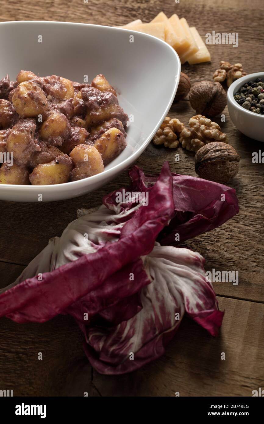 Gnocchi di patate senza glutine con salsa di radicchio, noci, pepe e parmigiano. Foto Stock