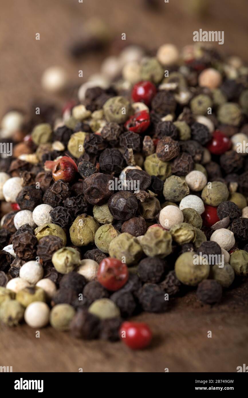 Macro primo piano di peperoni misti su un tavolo di legno. Foto Stock