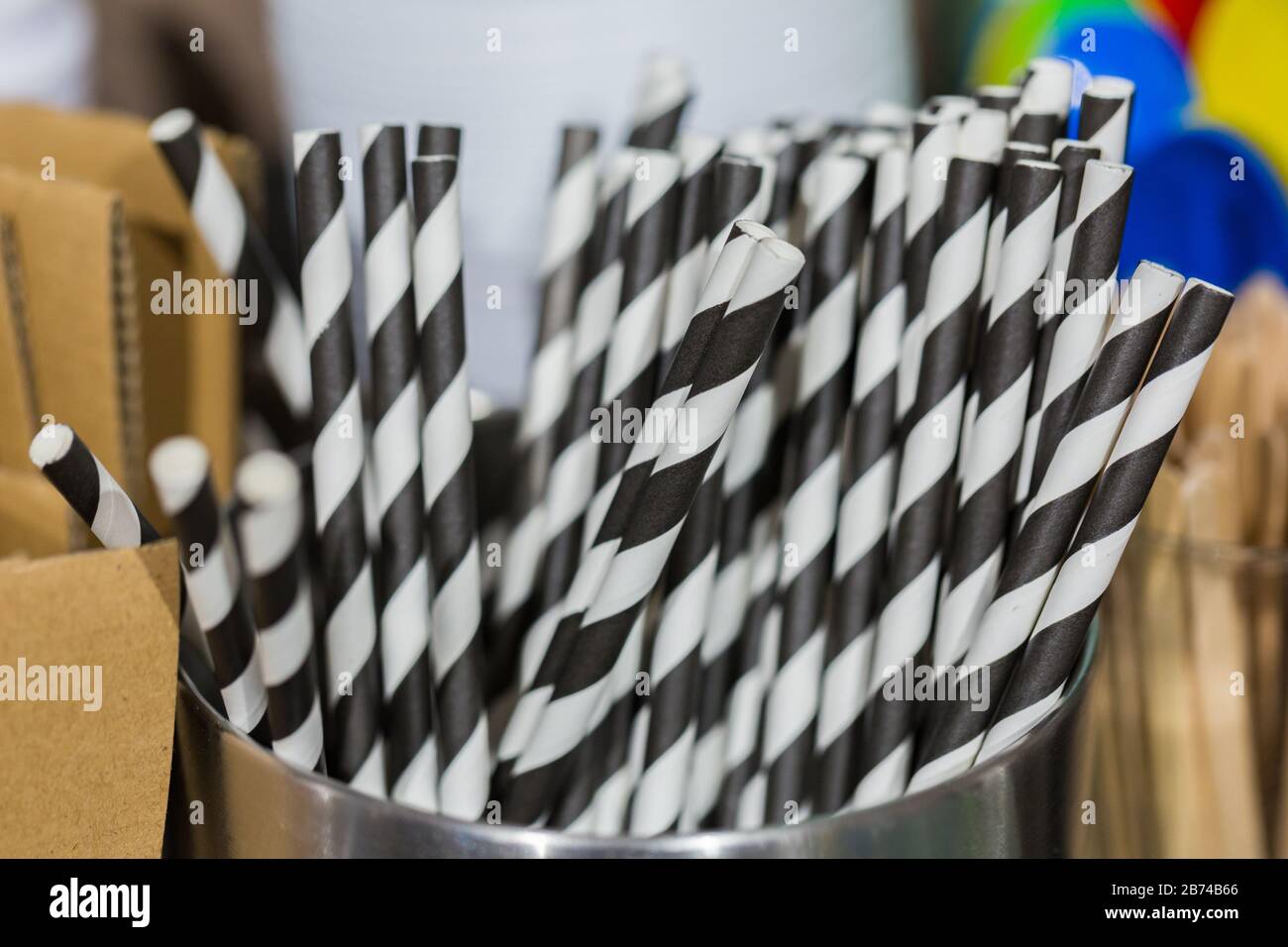 Primo piano di cannucce da bere in un vaso metallico. A righe bianche e nere, come caffè e latte. Per bere latte macchiato. Deve avere per ogni bar. Foto Stock