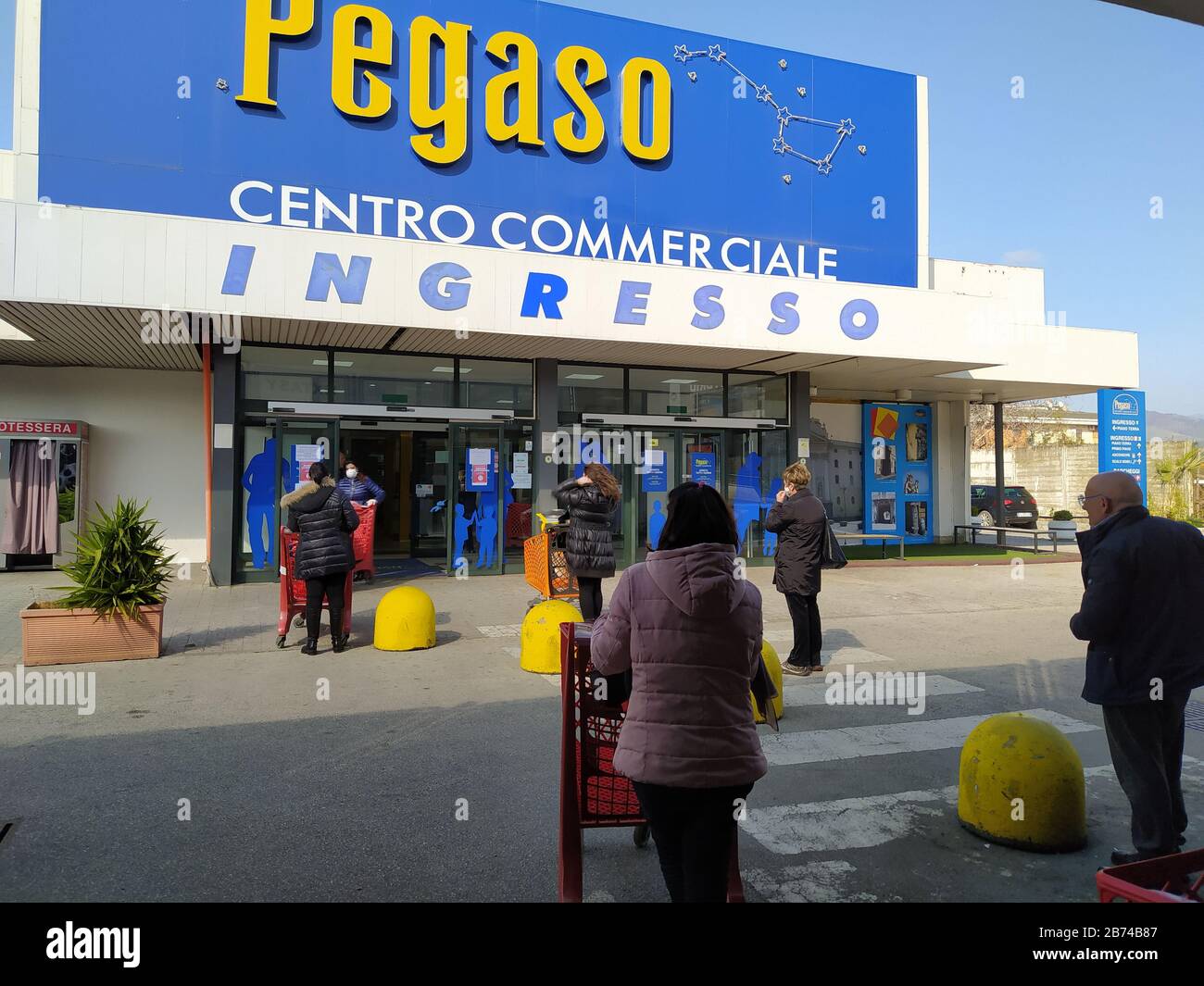 Le persone accodano al centro commerciale per rispettare la distanza di sicurezza di un metro come richiesto dal decreto legge per combattere il cavid-19 nei luoghi pubblici . Foto Stock