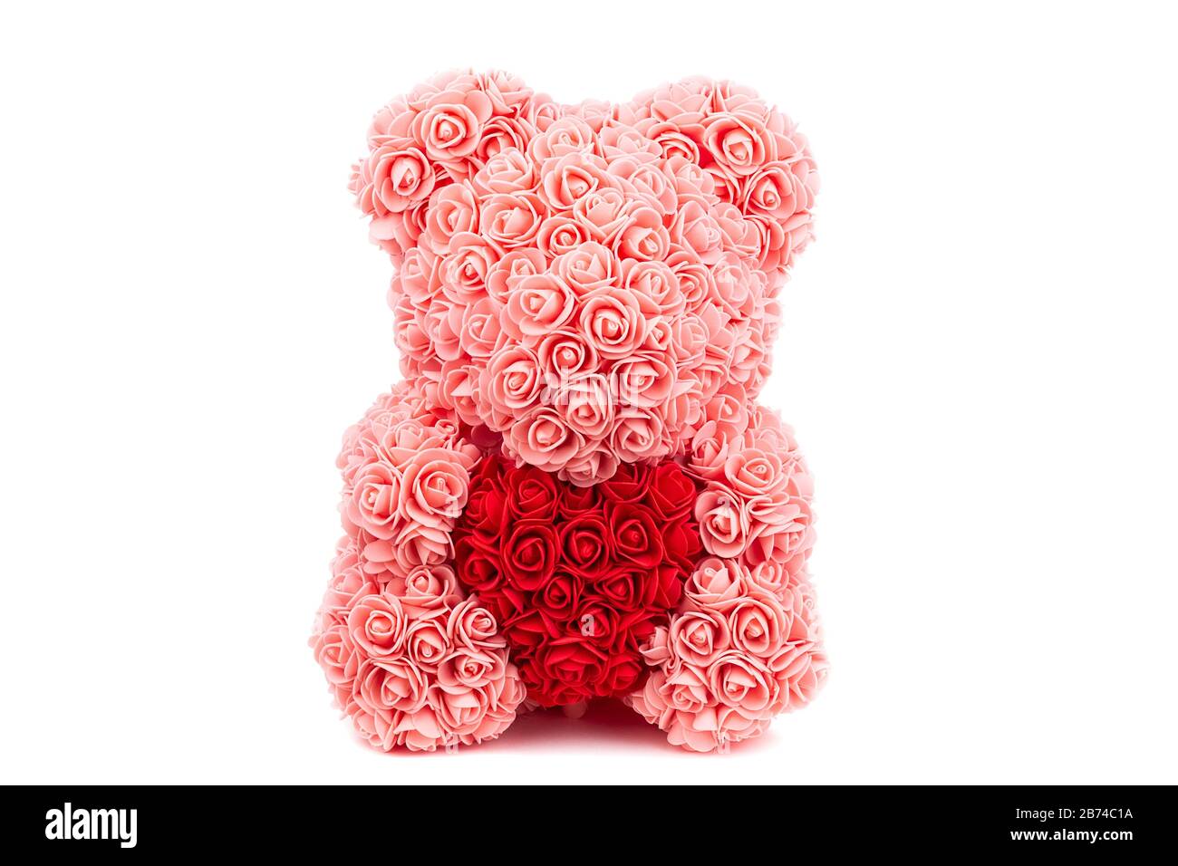 Cartolina al giorno degli amanti. Orso Teddy di rose rosa tiene un cuore rosso nelle sue mani su uno sfondo bianco Foto Stock