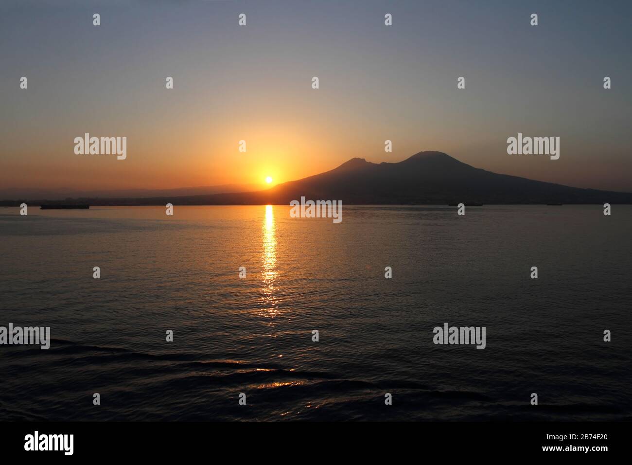 Napoli all'alba, le sole che sorge dietro il Vesuvio visto dal mare Foto  stock - Alamy