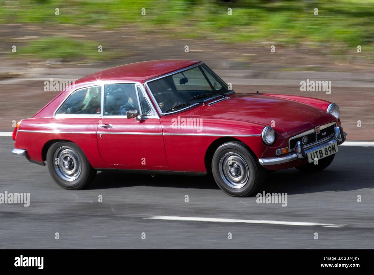 1973 70s RED MG B GT; traffico veicolare, trasporto, veicoli stradali, veicoli berlina, Veicolo su strade del Regno Unito, motori, motori sull'autostrada M6 Foto Stock