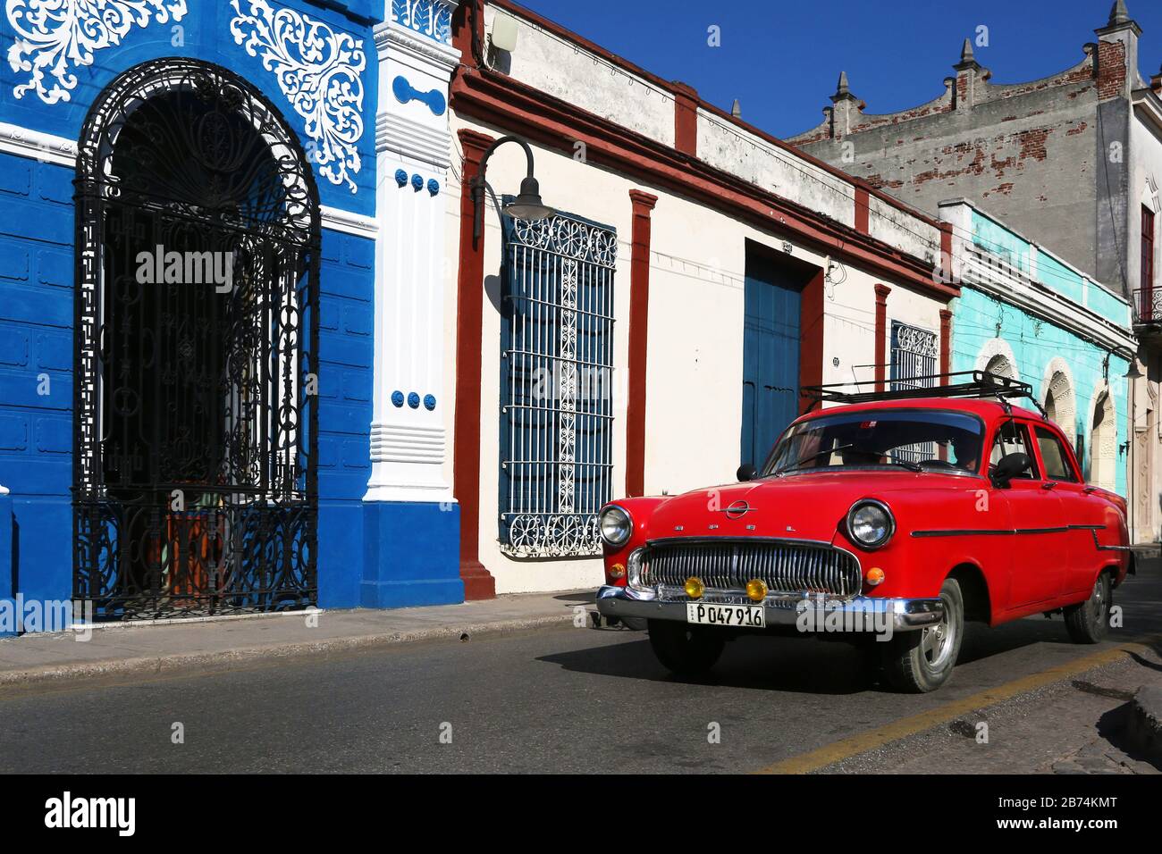 Havana, Cuba - tassista fotografare i turisti sulla sua Chevrolet classico rosa Foto Stock