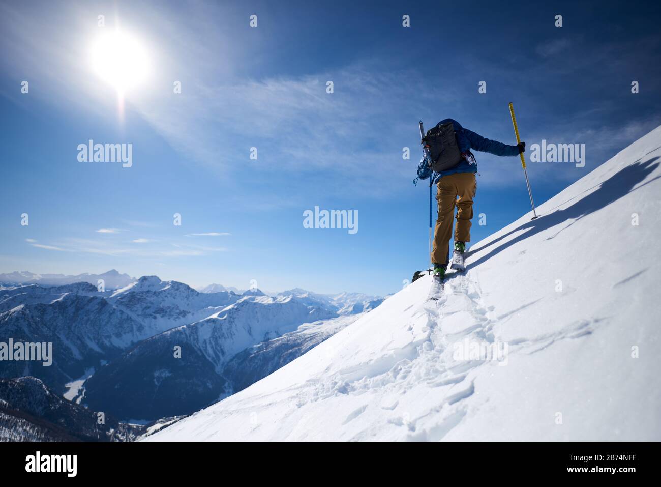 Sci alpinismo in salita con sfondo montano Foto Stock