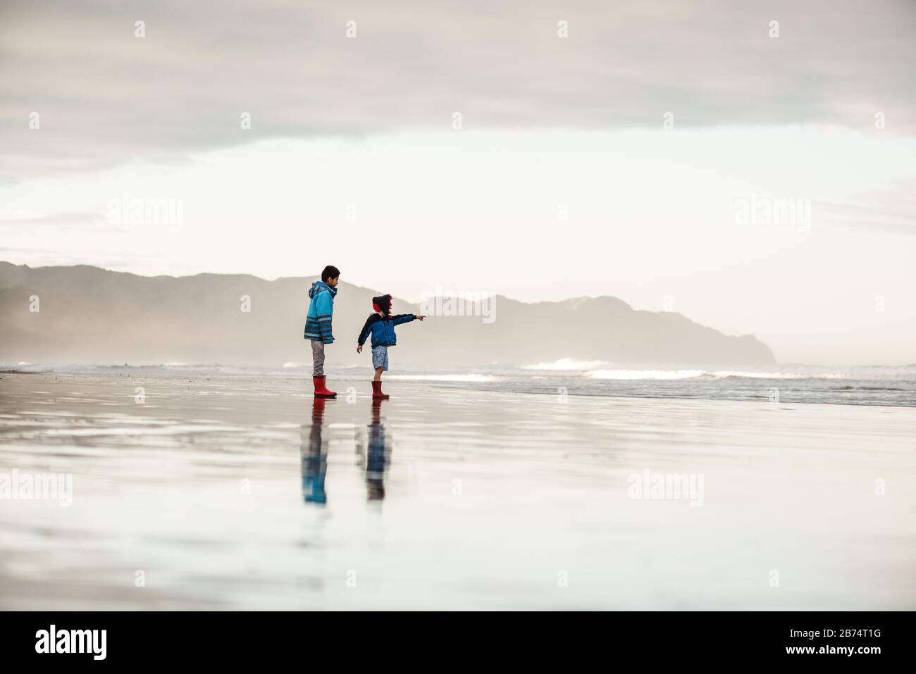 Fratelli in spiaggia in Nuova Zelanda il giorno d'inverno Foto Stock