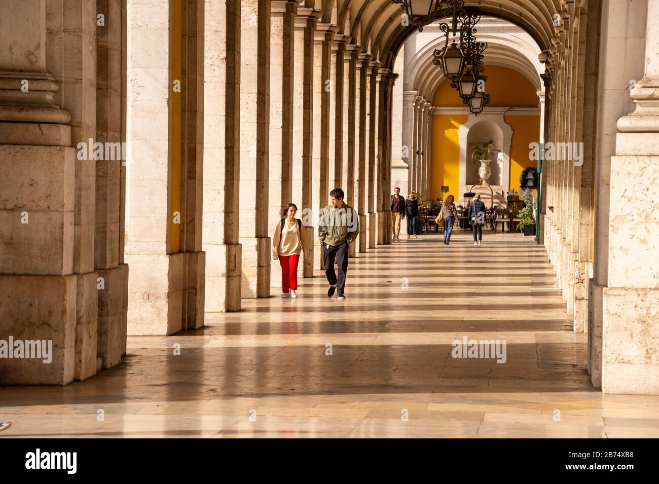 Lisbona, Portogallo - 2 marzo 2020: Pedoni che camminano lungo la passerella sotto l'edificio del Ministero della Giustizia vicino all'Arco da Rua Augusta Foto Stock