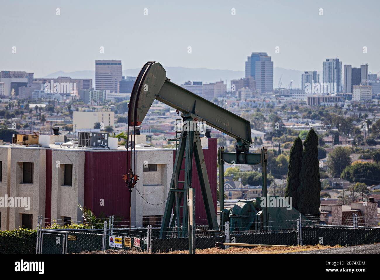 Pozzo di petrolio e martinetti nella città di Signal Hill con la città di Long Beach nel bacground. Una volta un'area di produzione massiccia di petrolio, i pozzi di petrolio sono ancora Foto Stock