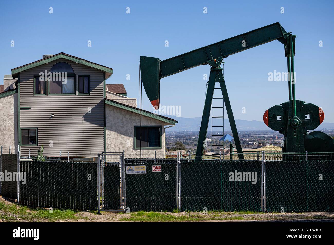 Pozzo di petrolio e martinetti nella Città di Signal Hill. Un tempo un'area di produzione massiccia di petrolio, i pozzi di petrolio sono ancora mescolati nei relativi quartieri residenziali ora. Foto Stock