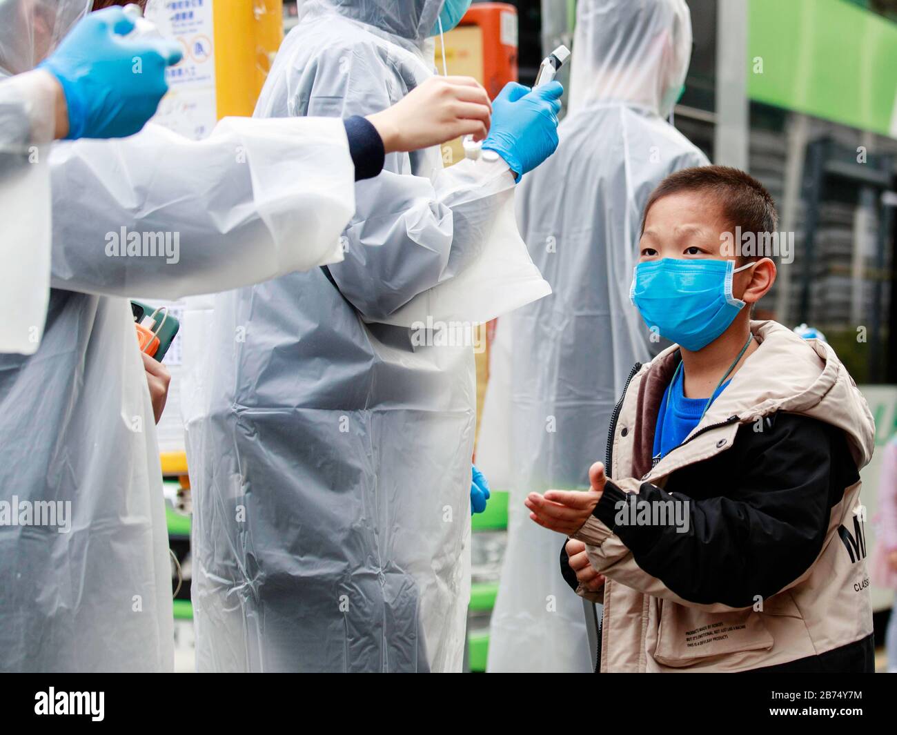 I residenti della comunità di Tin Shui Wai hanno collaborato per controllare la temperatura corporea dei passeggeri arrivati con un autobus transfrontaliero. Un uomo di trentanove anni a Hong Kong credeva di essere stata la prima vittima del Coronavirus. Foto Stock