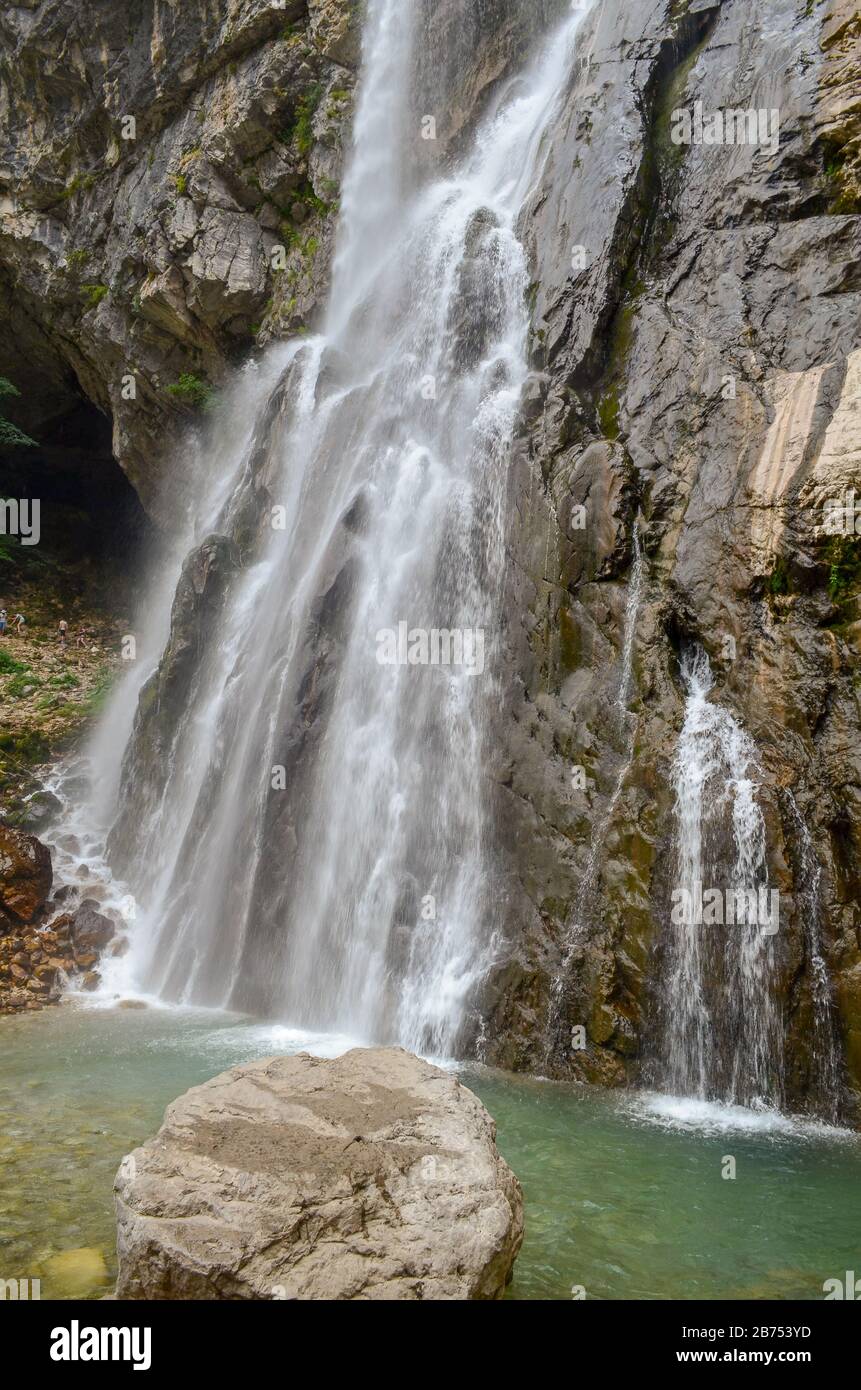 Cascata Gega nelle montagne dell'Abkhazia. Un gruppo di turisti accanto a quello. Si trova nelle zone settentrionali del Gagra Range ad un'altitudine o Foto Stock