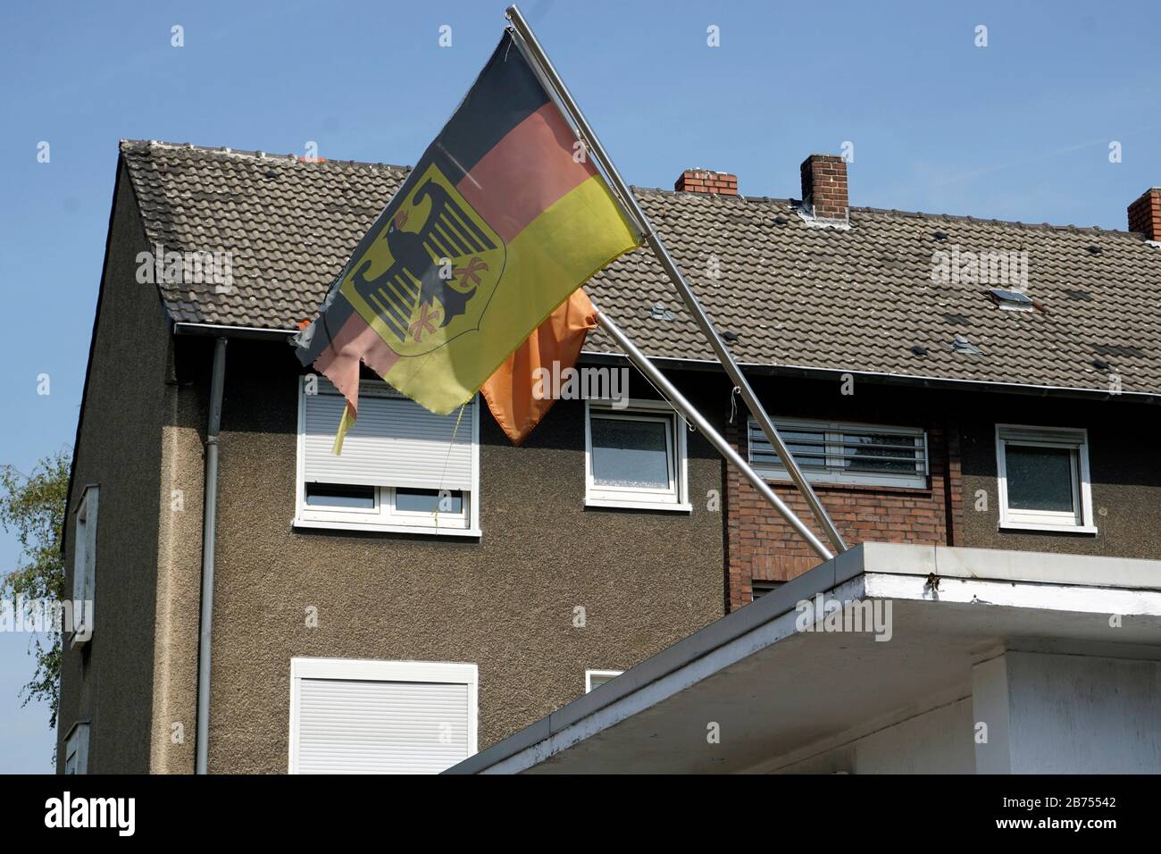 Una bandiera tedesca sfilacciata con un'aquila federale fiutola di fronte a una casa in Bottrop. [traduzione automatica] Foto Stock