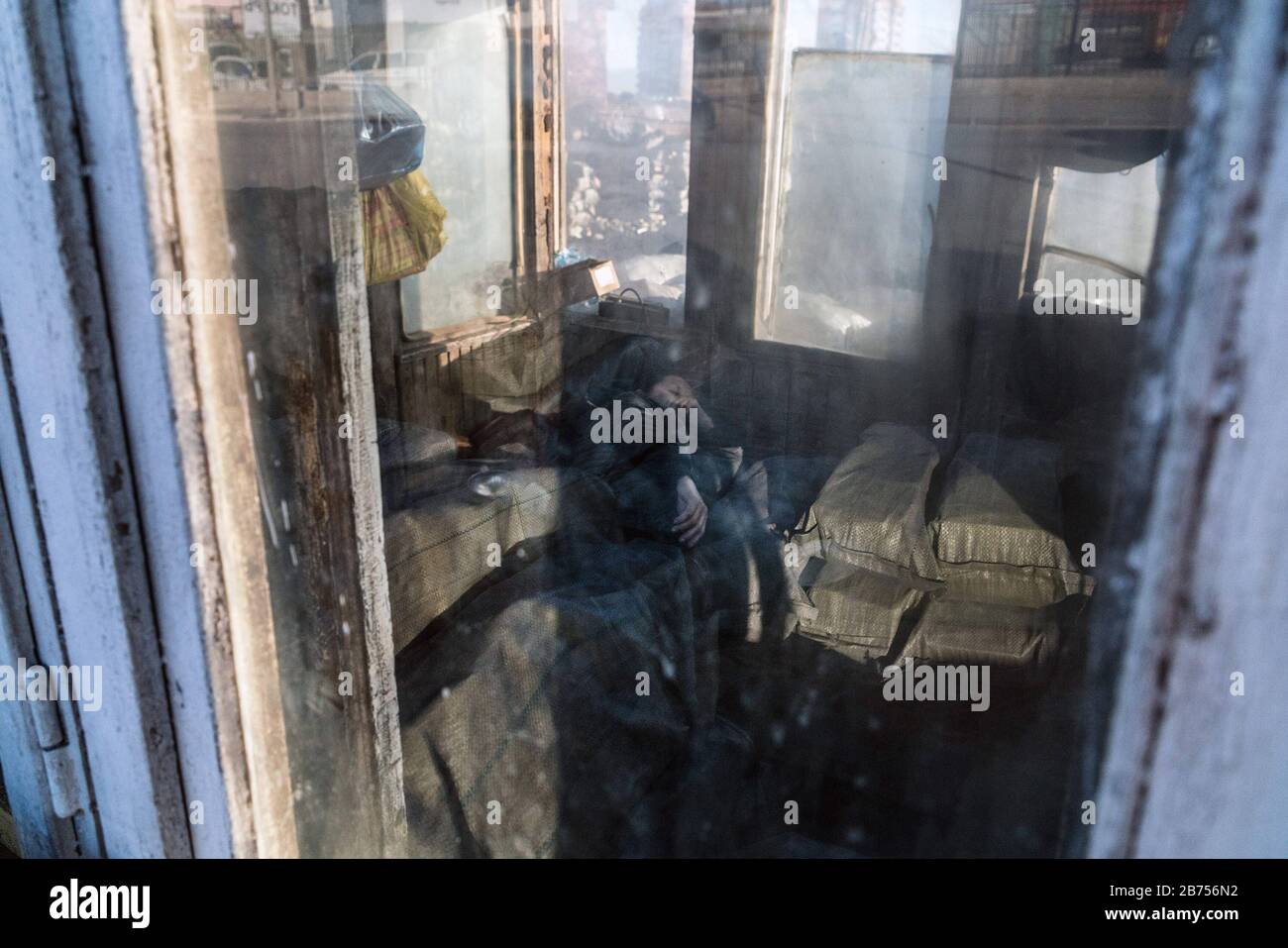 Un lavoratore è riposato durante la pausa pranzo. Lavora in un commercio di carbone e confeella sacchi di carbone per la vendita. [traduzione automatica] Foto Stock
